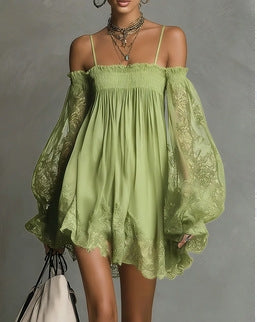 Woman wearing a green lace dress with sheer sleeves against a gray background