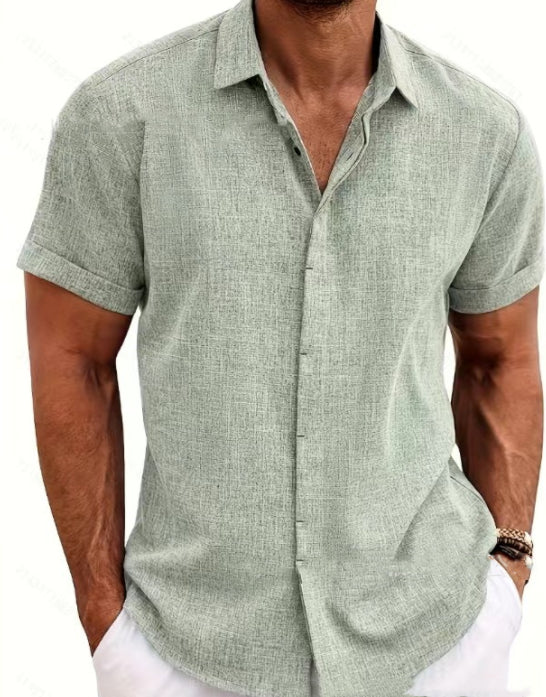 Man wearing a light green short-sleeve button-up shirt on a white background