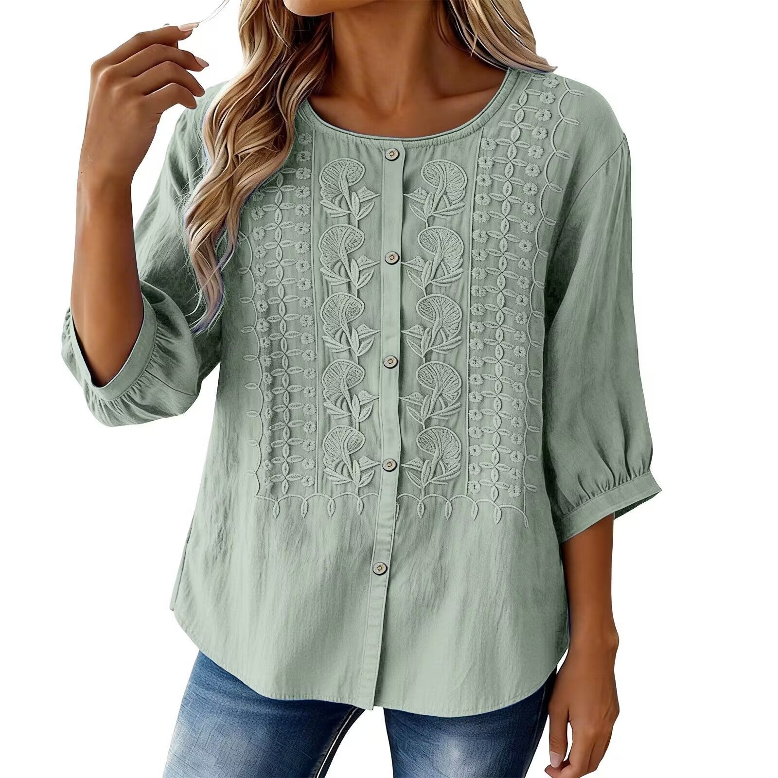 Green embroidered blouse worn by a model on a white background