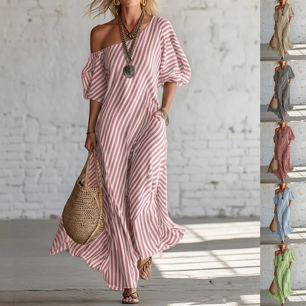 Woman wearing a pink and white striped dress with a white brick wall background