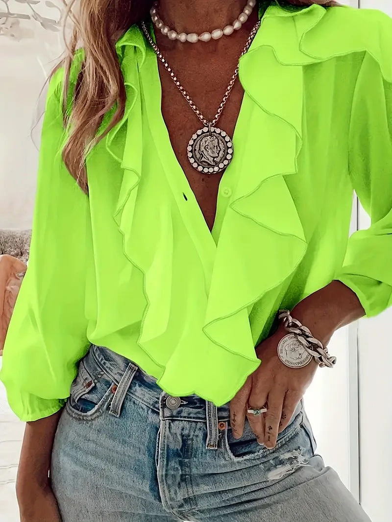 Person wearing a bright green blouse with ruffled details, denim jeans, and layered necklaces.