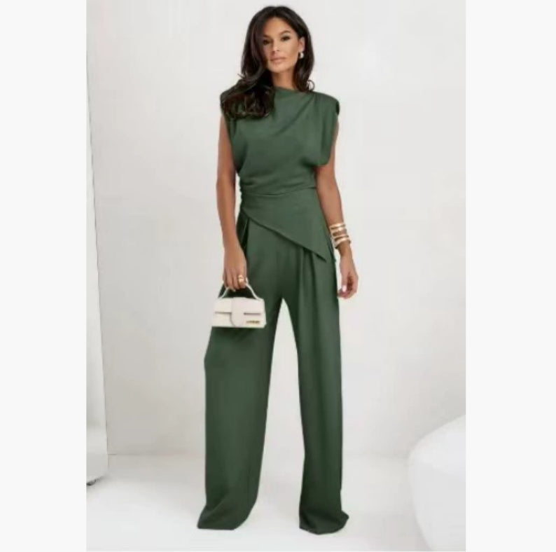 Woman wearing a green jumpsuit holding a white handbag on a white background