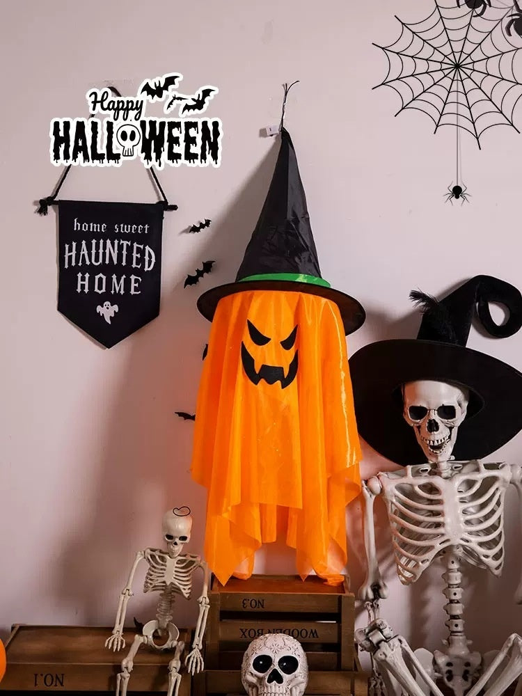 Halloween-themed decorations including a witch hat, orange cape with ghost face, skeletons, and spider webs.