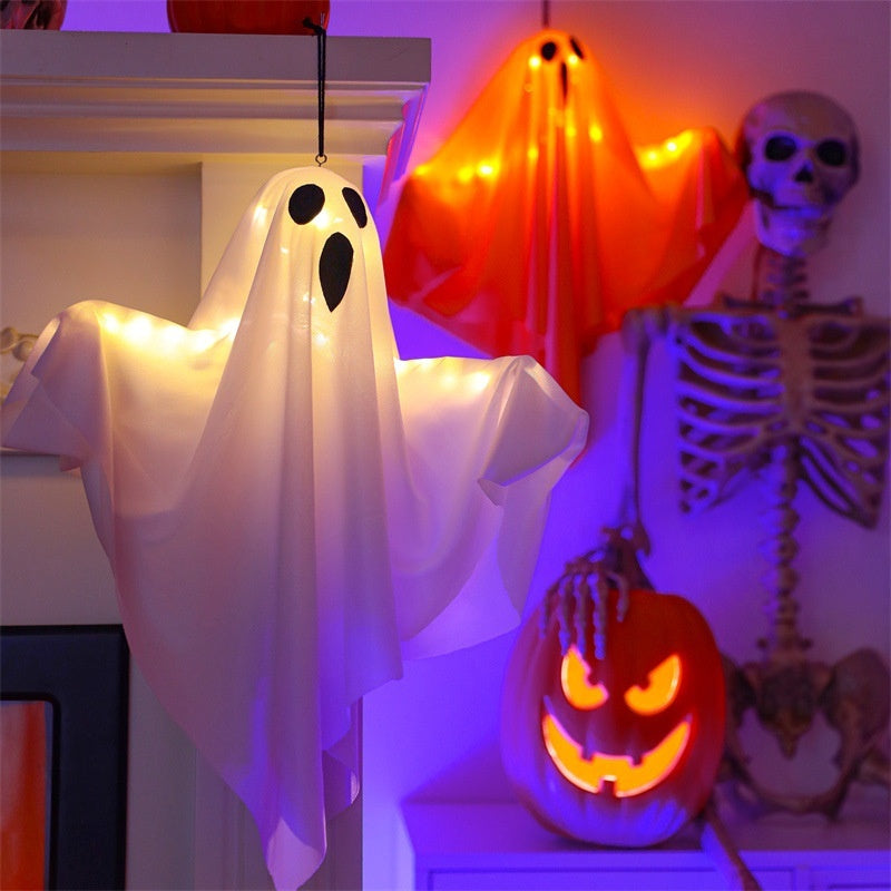 Halloween decorations including a ghost, skeleton, and jack-o'-lantern on a shelf.