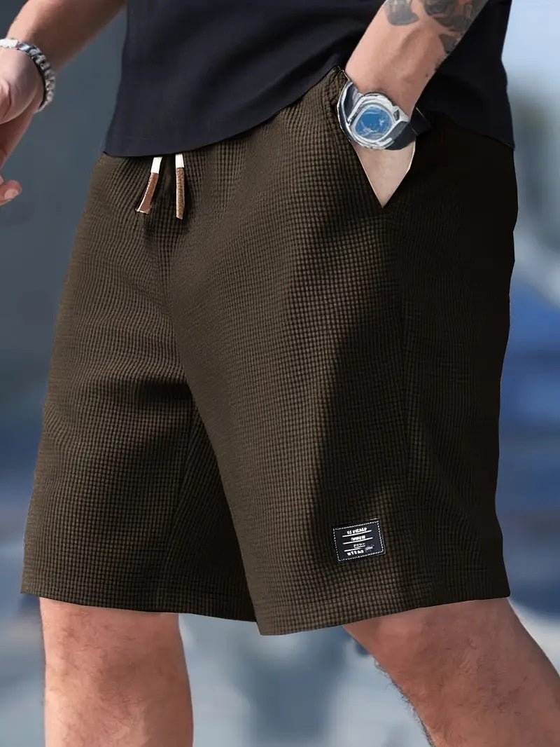 Brown checkered shorts worn by a person with a blurred background