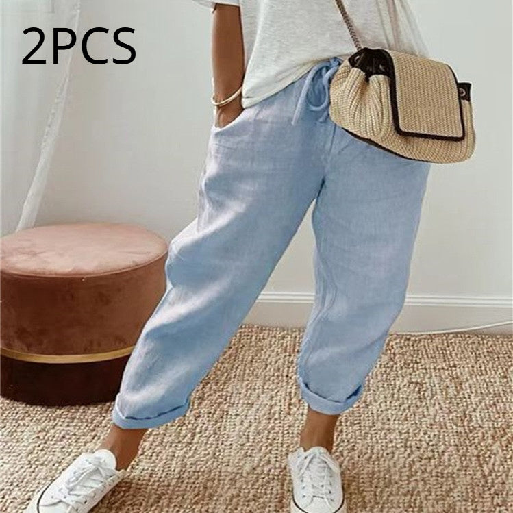 Person wearing light blue pants and white sneakers with a straw bag, standing on a carpeted floor.