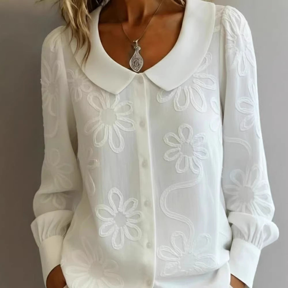 White blouse with floral embroidery on a plain background