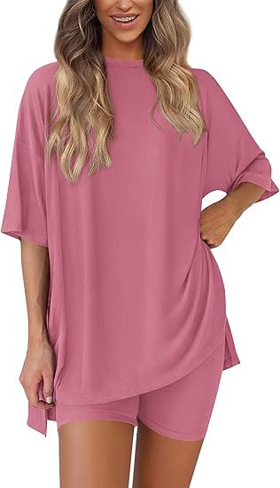 Woman wearing a pink oversized t-shirt and shorts set on a white background
