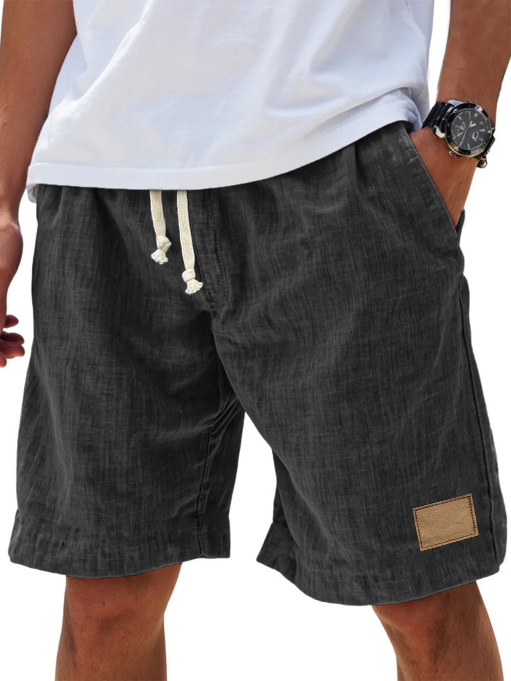 Dark gray shorts with a drawstring and brand patch on a white background