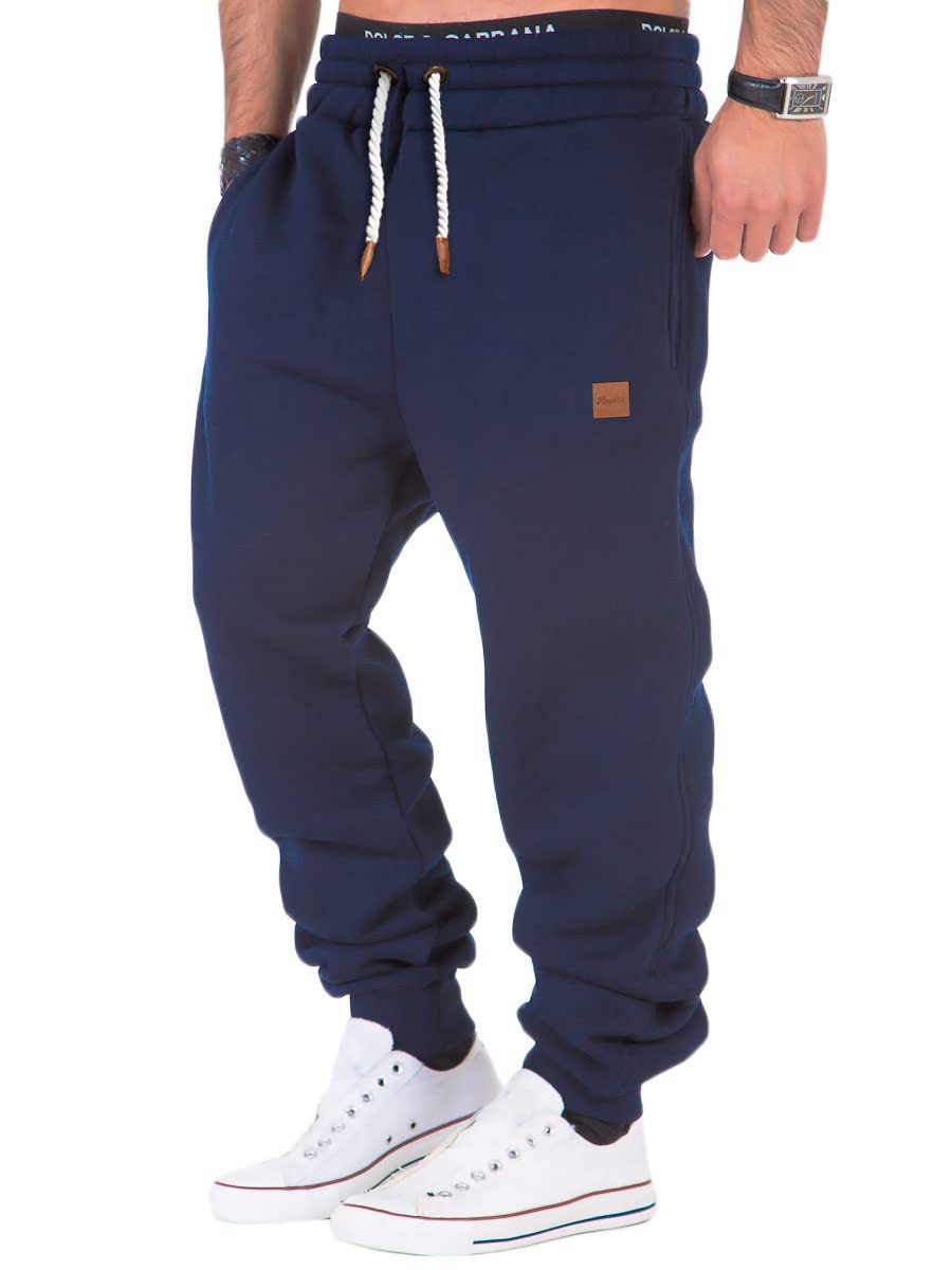Navy blue jogger pants worn by a person on a white background