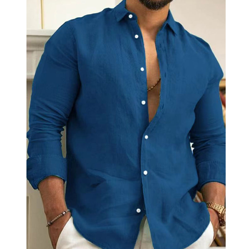 Man wearing a blue button-up shirt with white buttons, standing indoors.