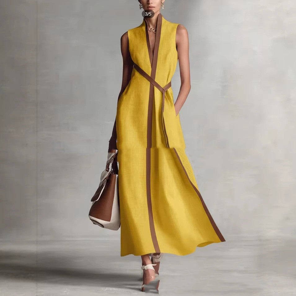 Woman wearing a yellow dress with brown accents against a gray background