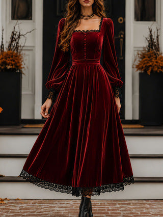 Woman wearing a red velvet dress with black lace trim on a staircase.