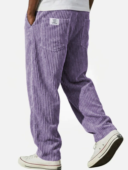 Purple corduroy pants worn by a person on a white background