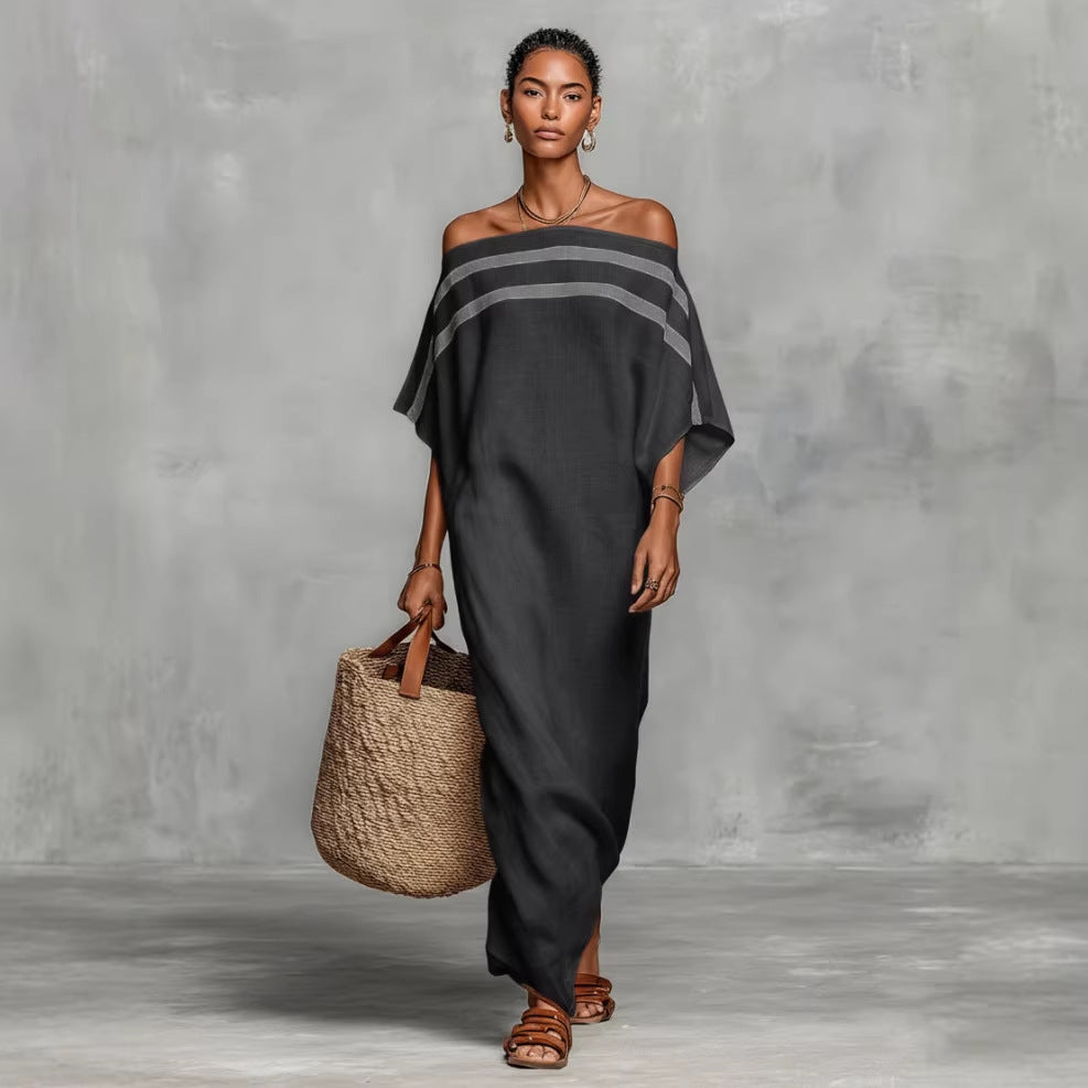 Woman wearing a black off-shoulder dress holding a woven bag against a gray background