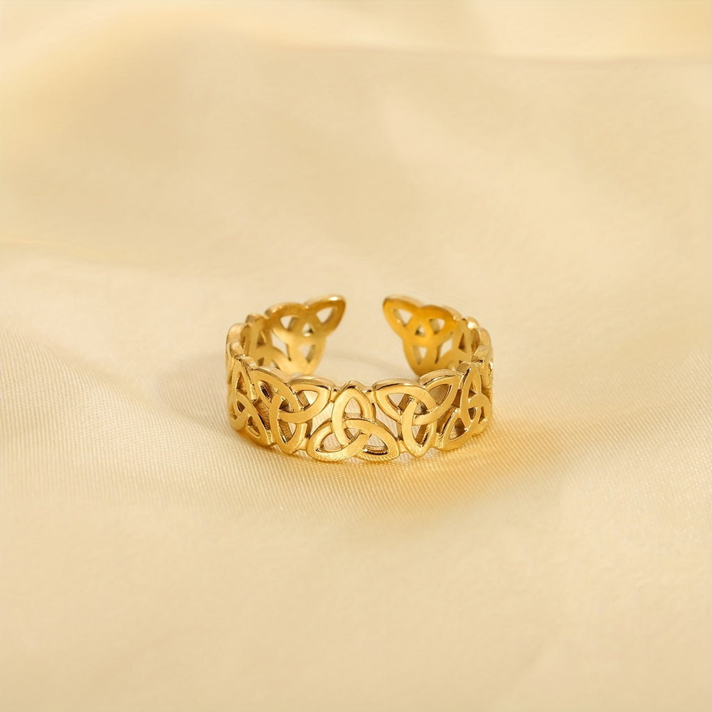 Gold openwork ring on a beige fabric background