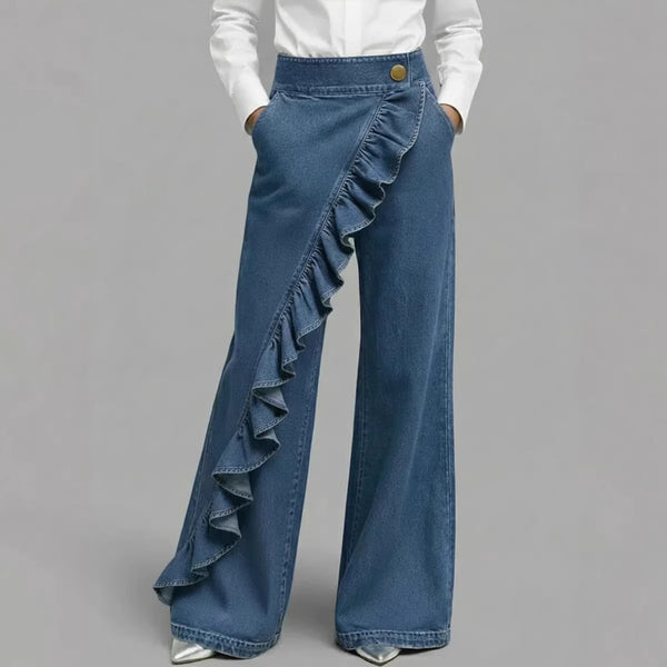 Blue denim pants with ruffles on a gray background