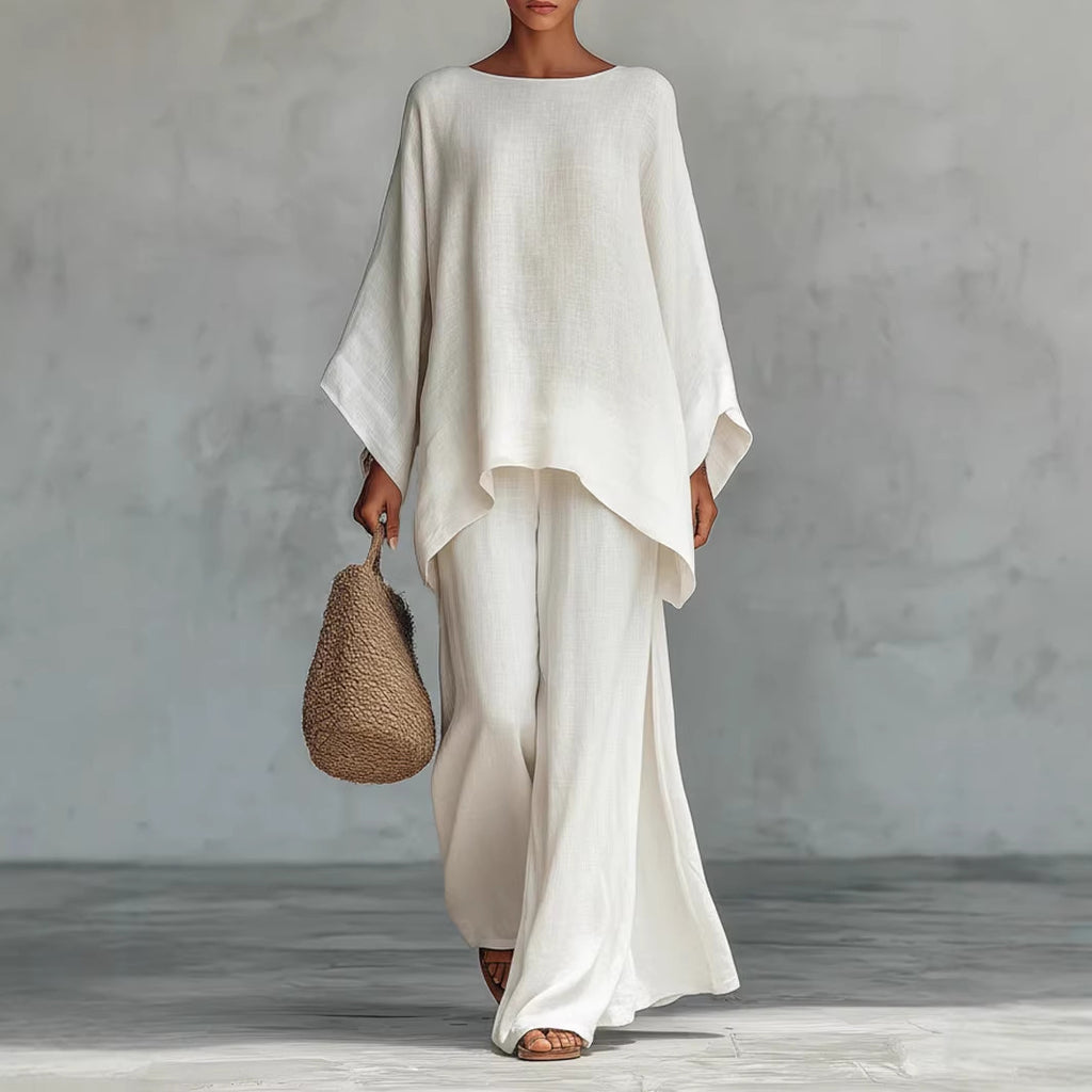 Person wearing a white outfit holding a woven bag against a gray background