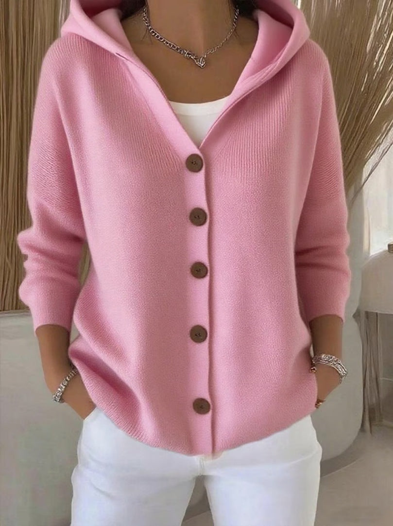 Pink cardigan with brown buttons worn by a person indoors.