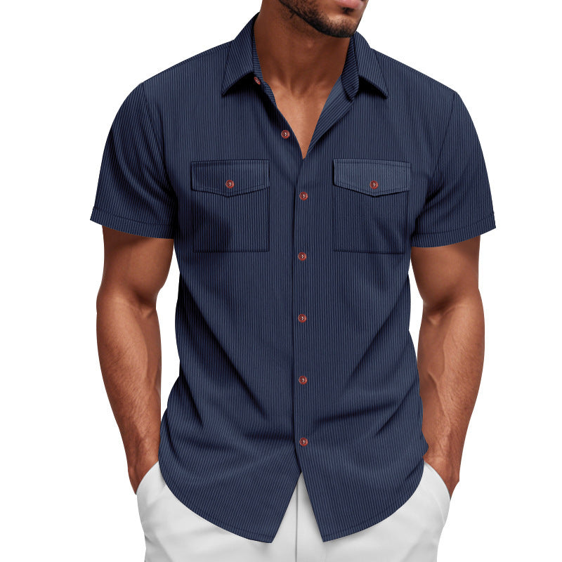Man wearing a navy short-sleeve shirt with red buttons on a white background