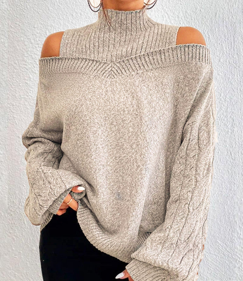 Beige sweater with cut-out shoulders worn by a person against a white background