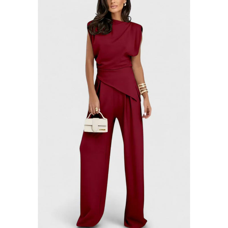 Woman wearing a red jumpsuit holding a small handbag on a white background