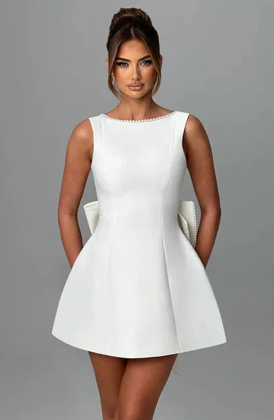 Woman wearing a white dress against a gray background
