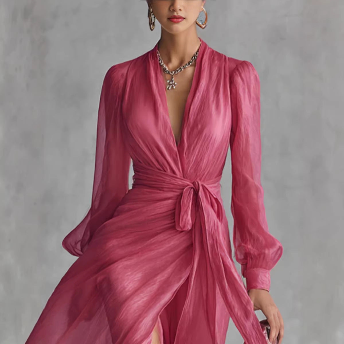 Woman wearing a pink dress with long sleeves against a gray background