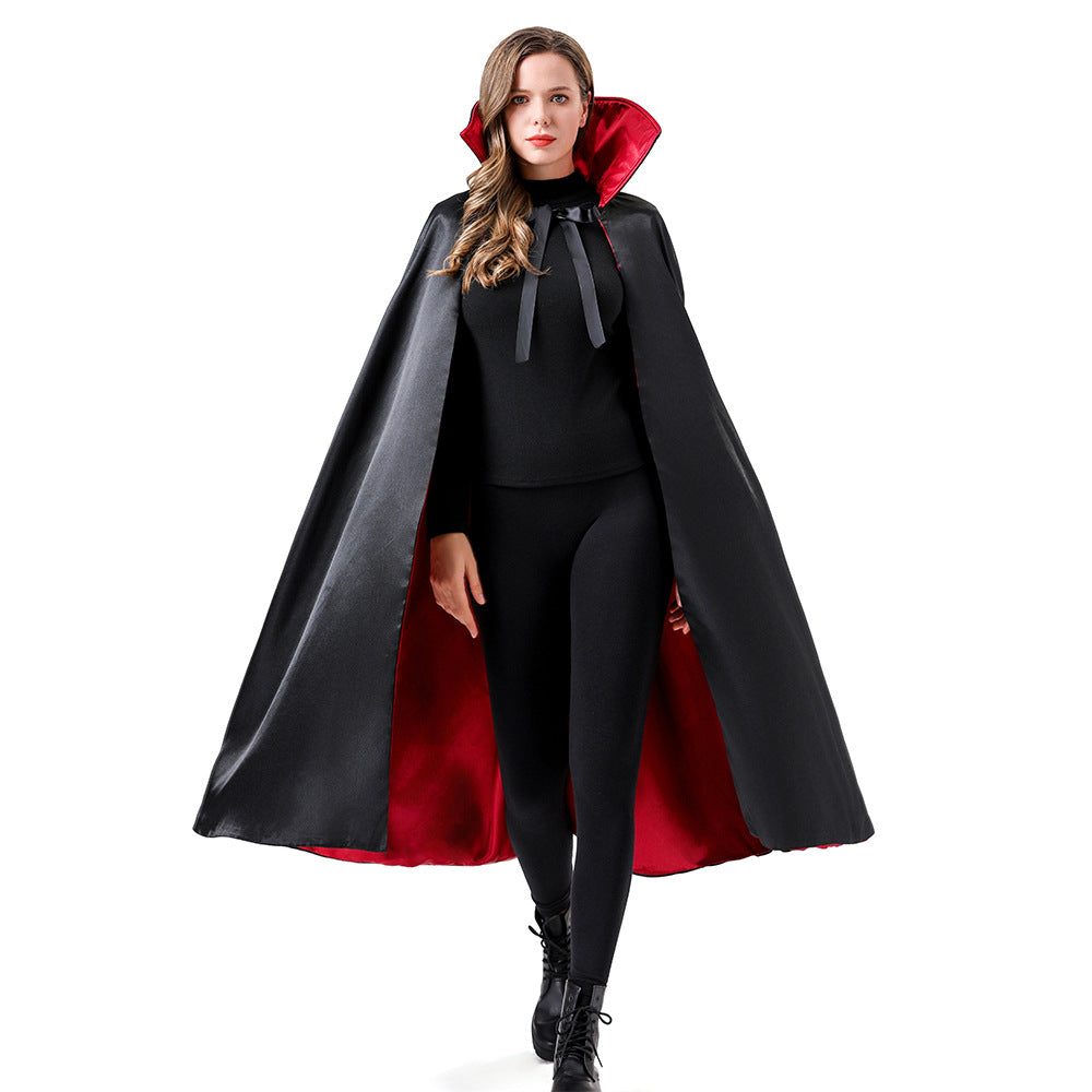 A woman modeling a black vampire-style cape with a bright red inner lining and a matching red hood, worn over a black outfit against a plain white background.