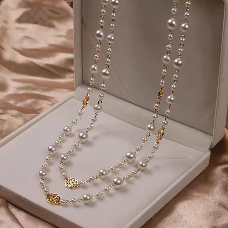 Pearl necklace with gold accents on a white jewelry box