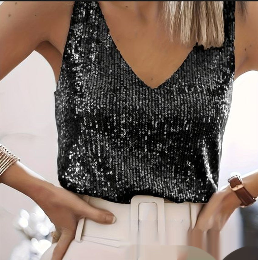 Person wearing a black sequin top with a blurred background