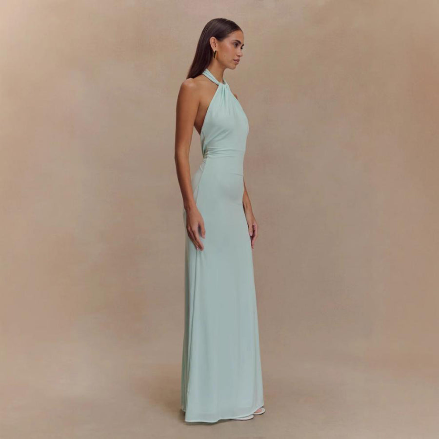 Woman wearing a light blue halter neck gown against a beige background
