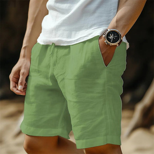 Person wearing green shorts and a white shirt with a watch on a blurred background