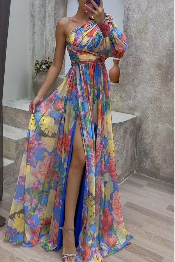 Colorful floral dress with a slit worn by a person, standing against a neutral background.