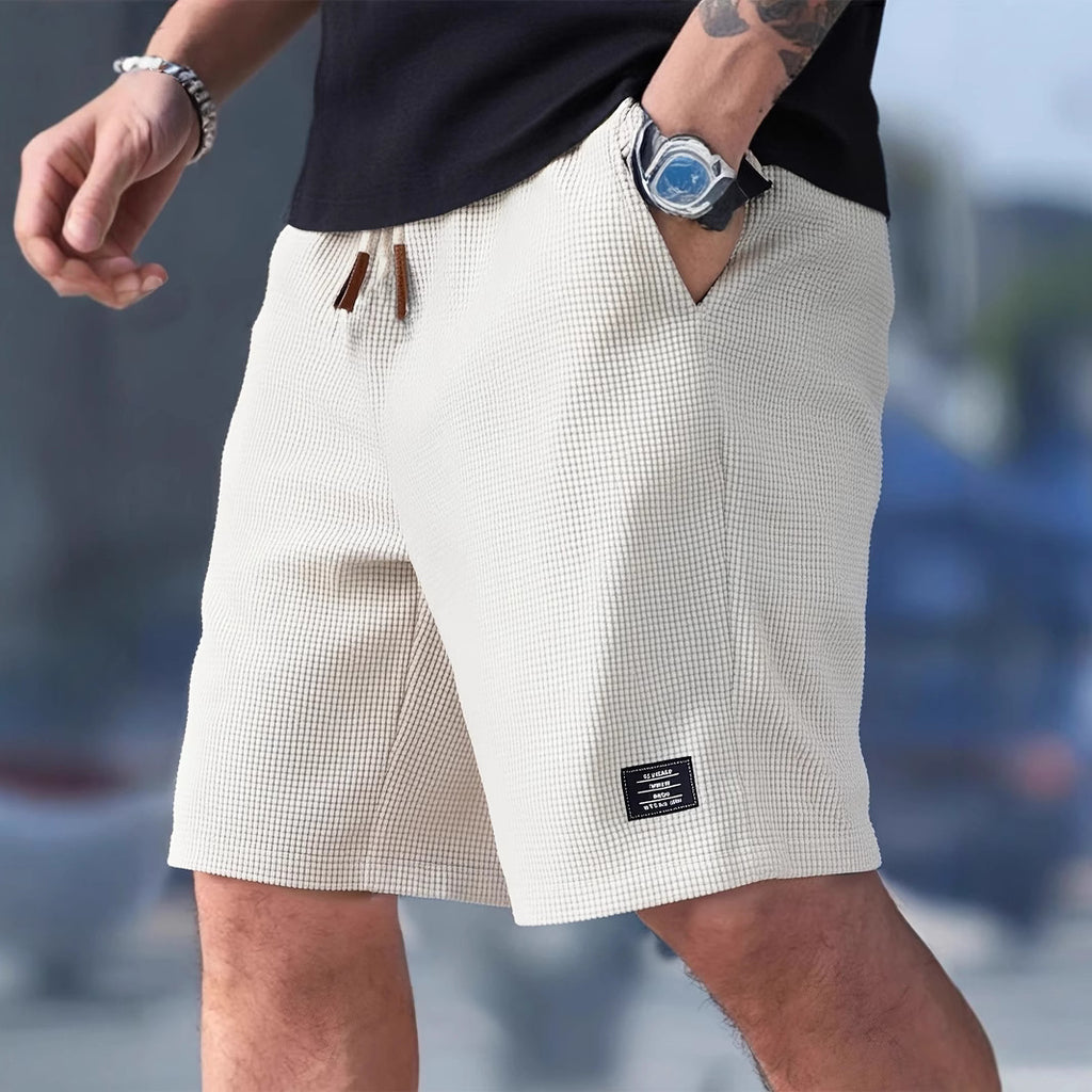 Person wearing white checkered shorts with a blurred background