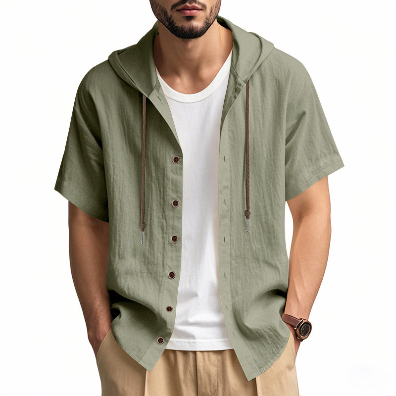 Man wearing a green short-sleeve hooded shirt over a white t-shirt on a white background