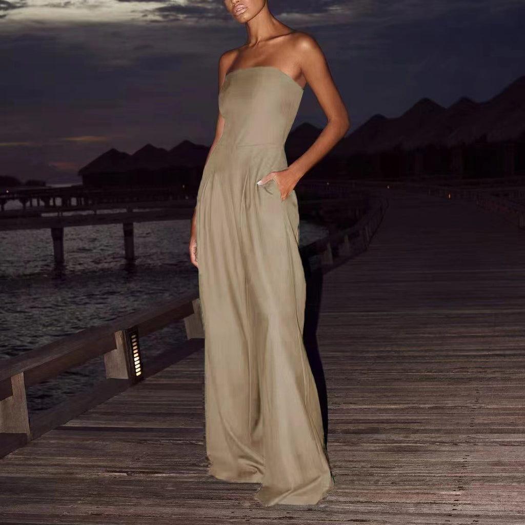 Woman in a strapless green dress standing on a wooden dock at dusk.