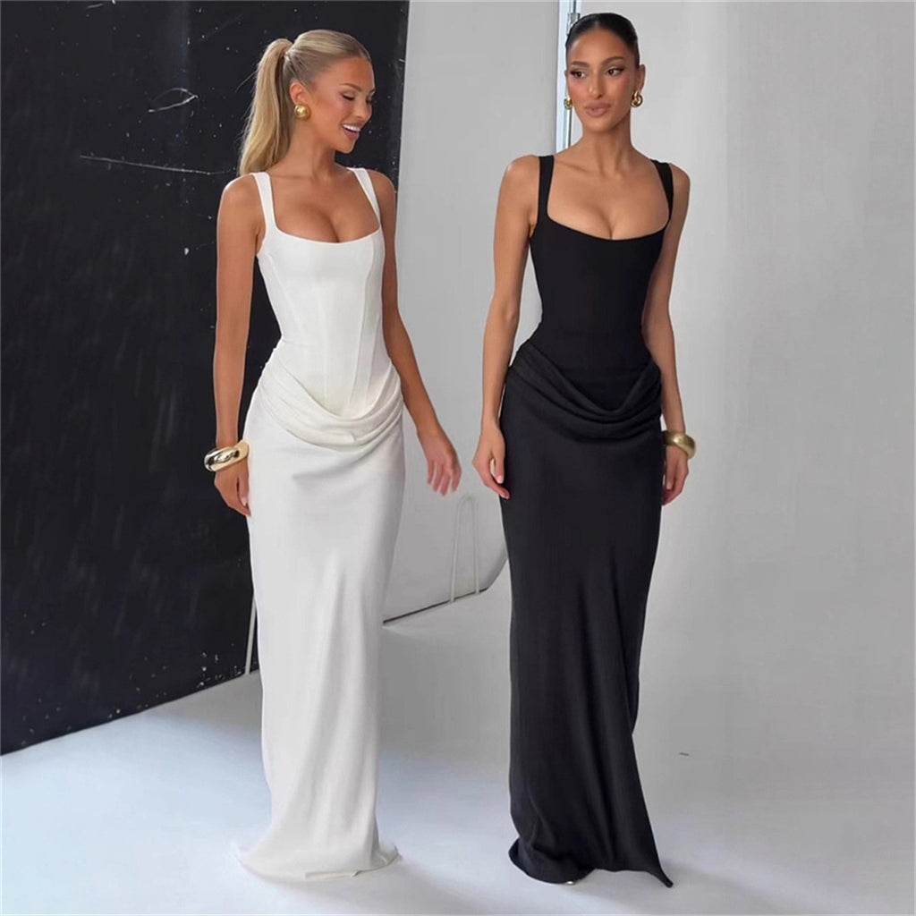 Two women wearing elegant evening gowns, one white and one black, against a neutral background.