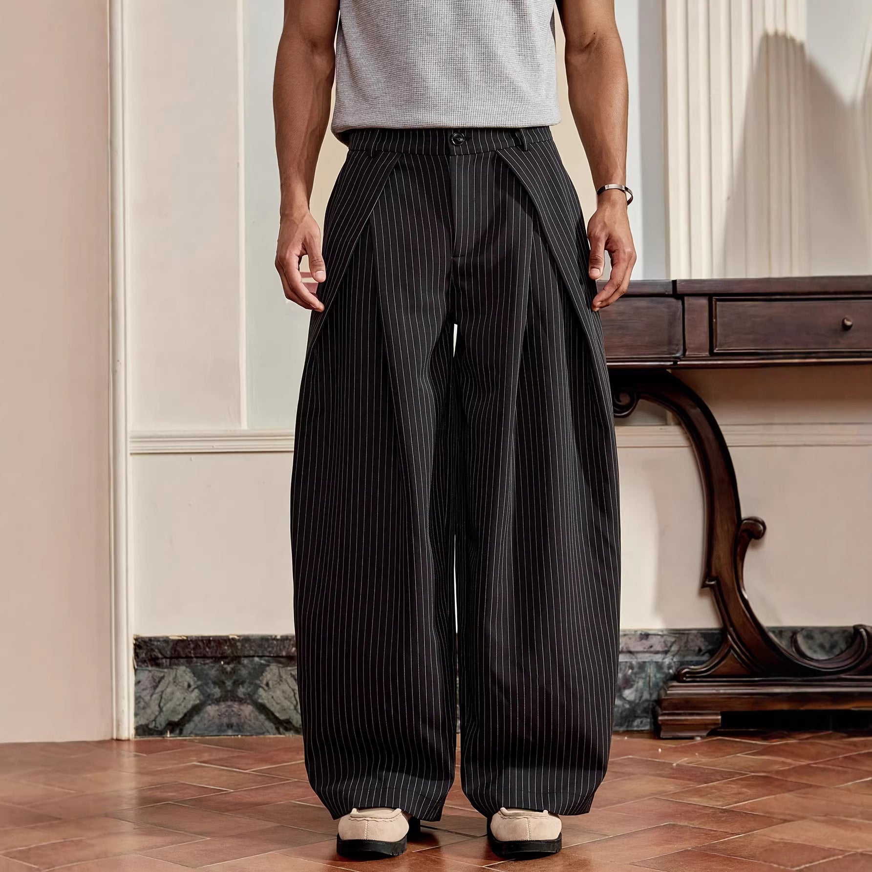 Person wearing black pinstripe pants in an indoor setting
