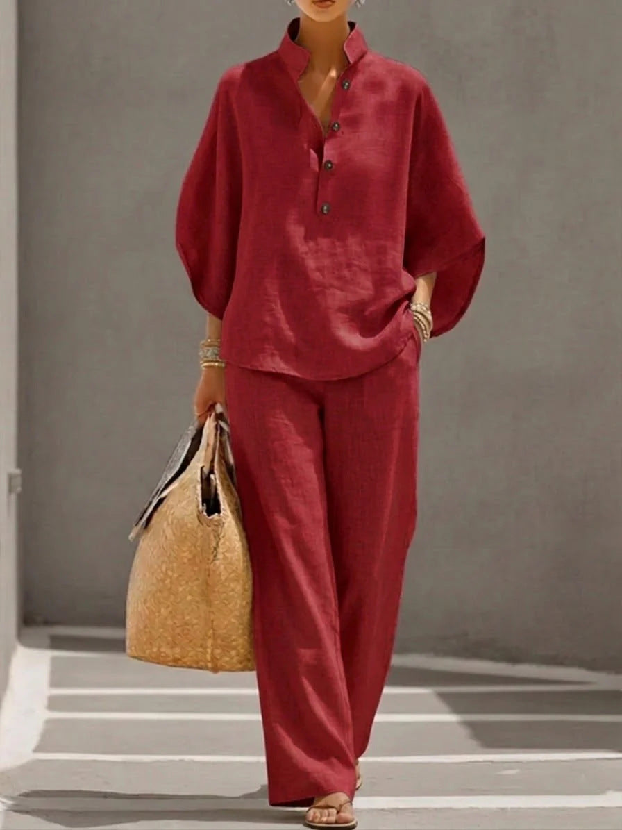Person wearing a red outfit holding a straw bag against a gray background