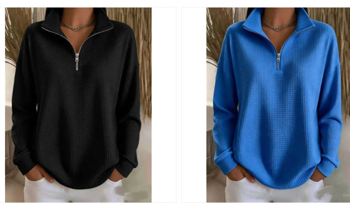 Two women's quarter-zip long-sleeve pullover sweaters shown side by side, one in black and one in bright blue, both with a waffle texture and silver zipper, worn by models with white pants.