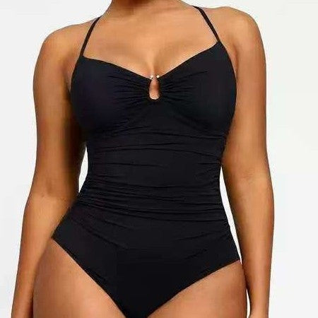 Black swimsuit worn by a model on a plain background