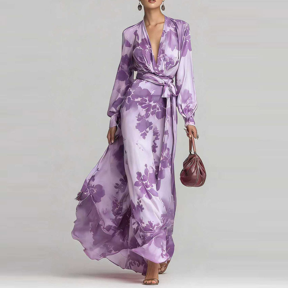 Woman wearing a purple floral dress holding a matching handbag against a white background