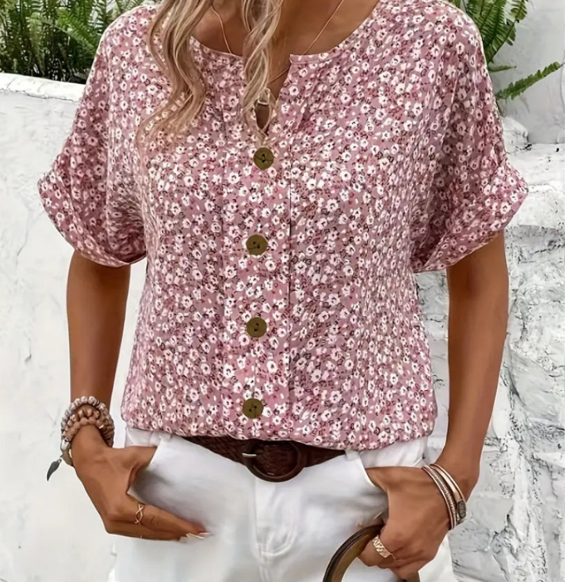 Woman wearing a pink floral blouse with buttons against a white background