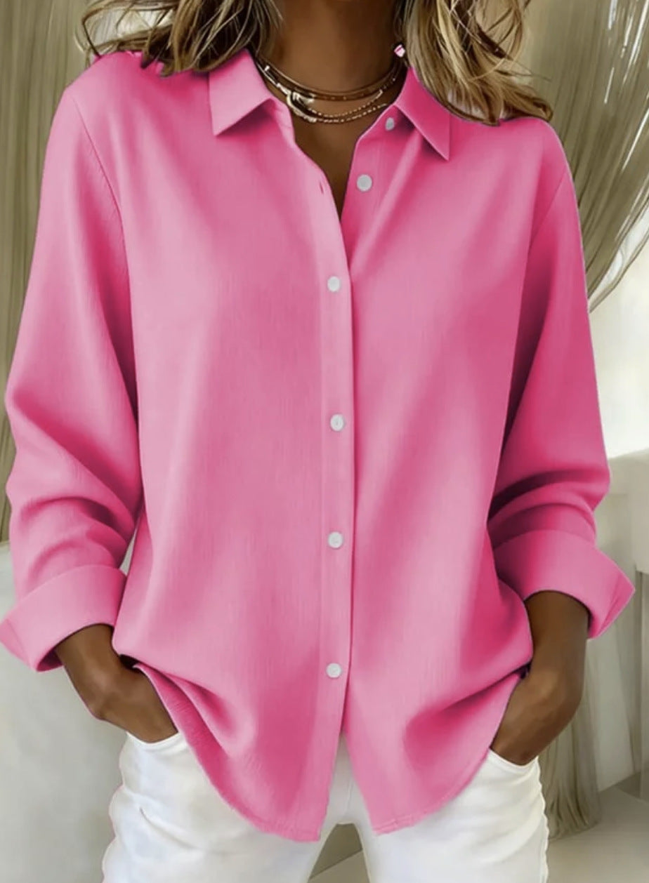 Person wearing a pink button-up shirt and white pants against a neutral background