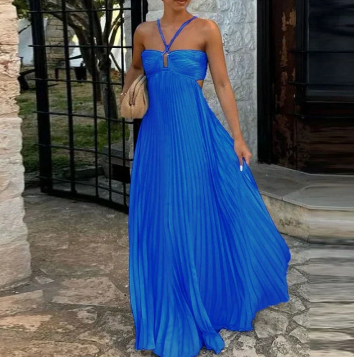 Woman wearing a blue dress standing outdoors on a stone path.