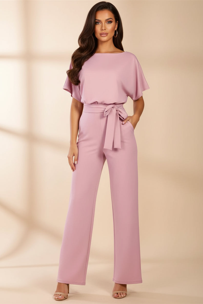 Woman wearing a pink jumpsuit on a white background