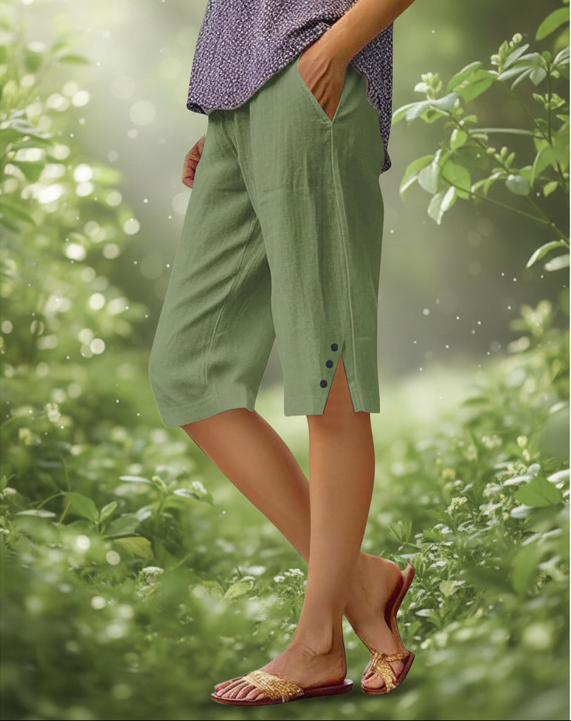 Green shorts worn by a person with a blurred background of plants