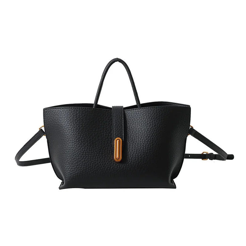 Black leather handbag with a gold clasp on a white background