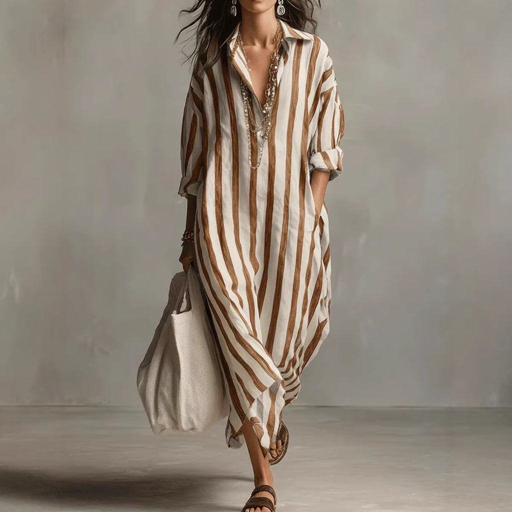 Woman wearing a long, striped dress with a plain background